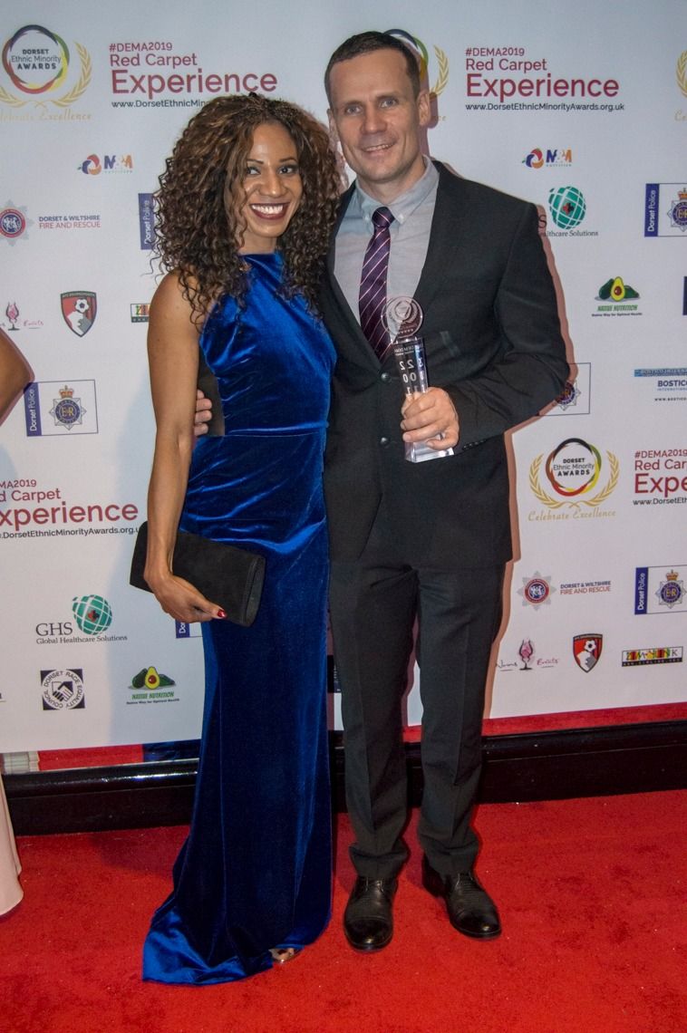 Two guests with a trophy on the red carpet