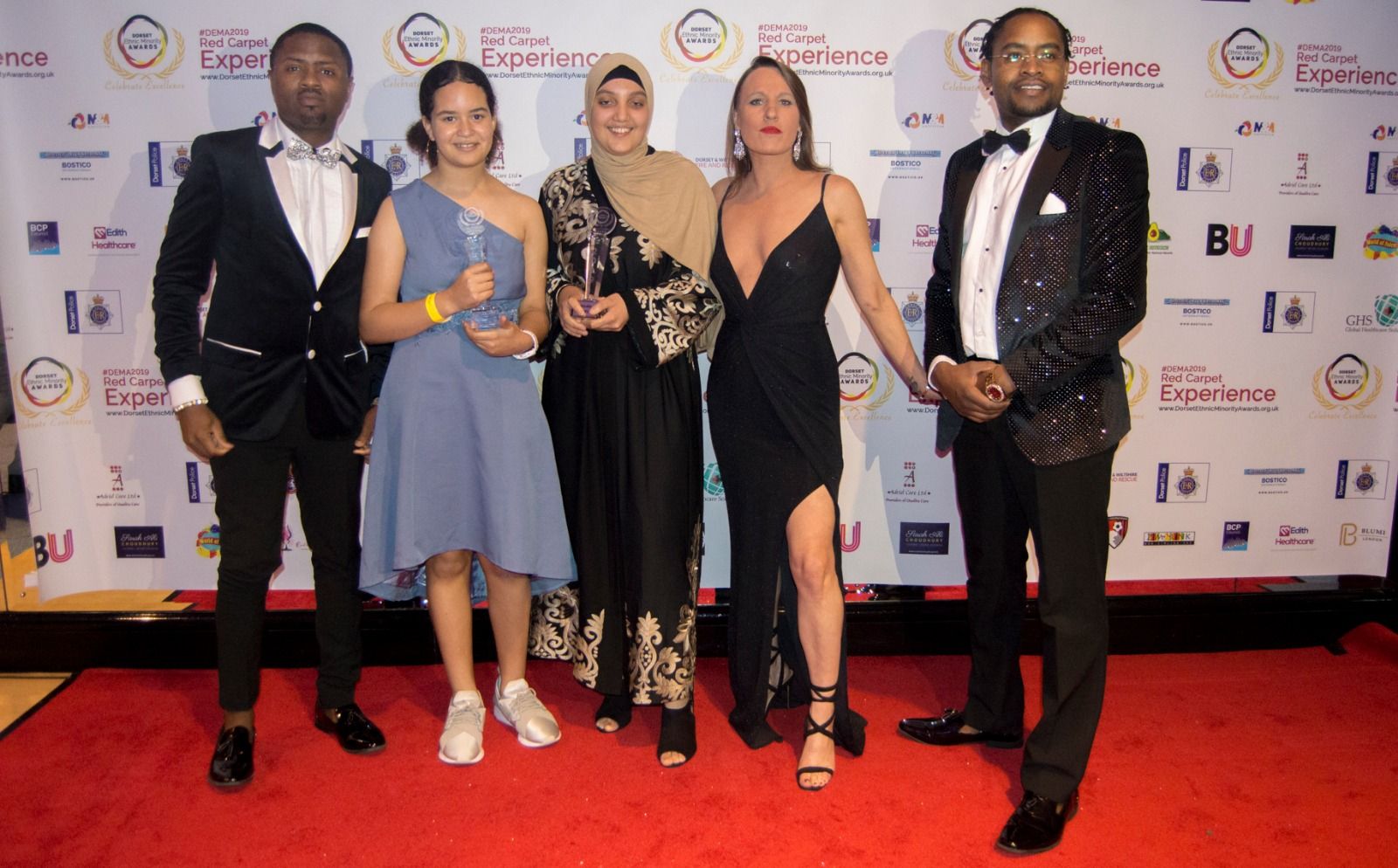 Five guests with a trophy on the red carpet
