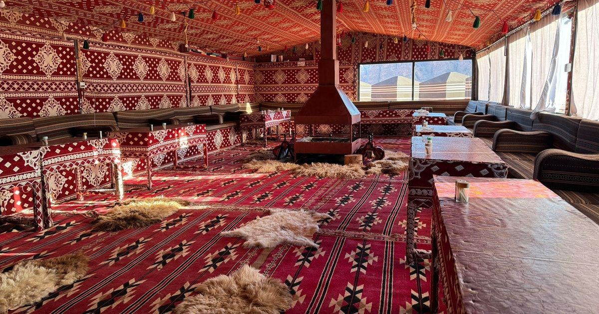 Beduiński namiot z dywanami i niskimi stołami, w którym po safari podawana jest kolacja