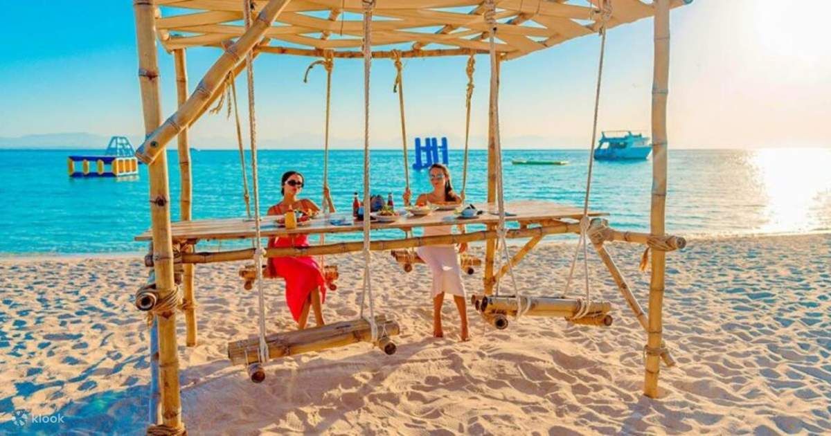 Stolik z bambusowymi huśtawkami na plaży Wyspy Paradise o zachodzie słońca nad Morzem Czerwonym