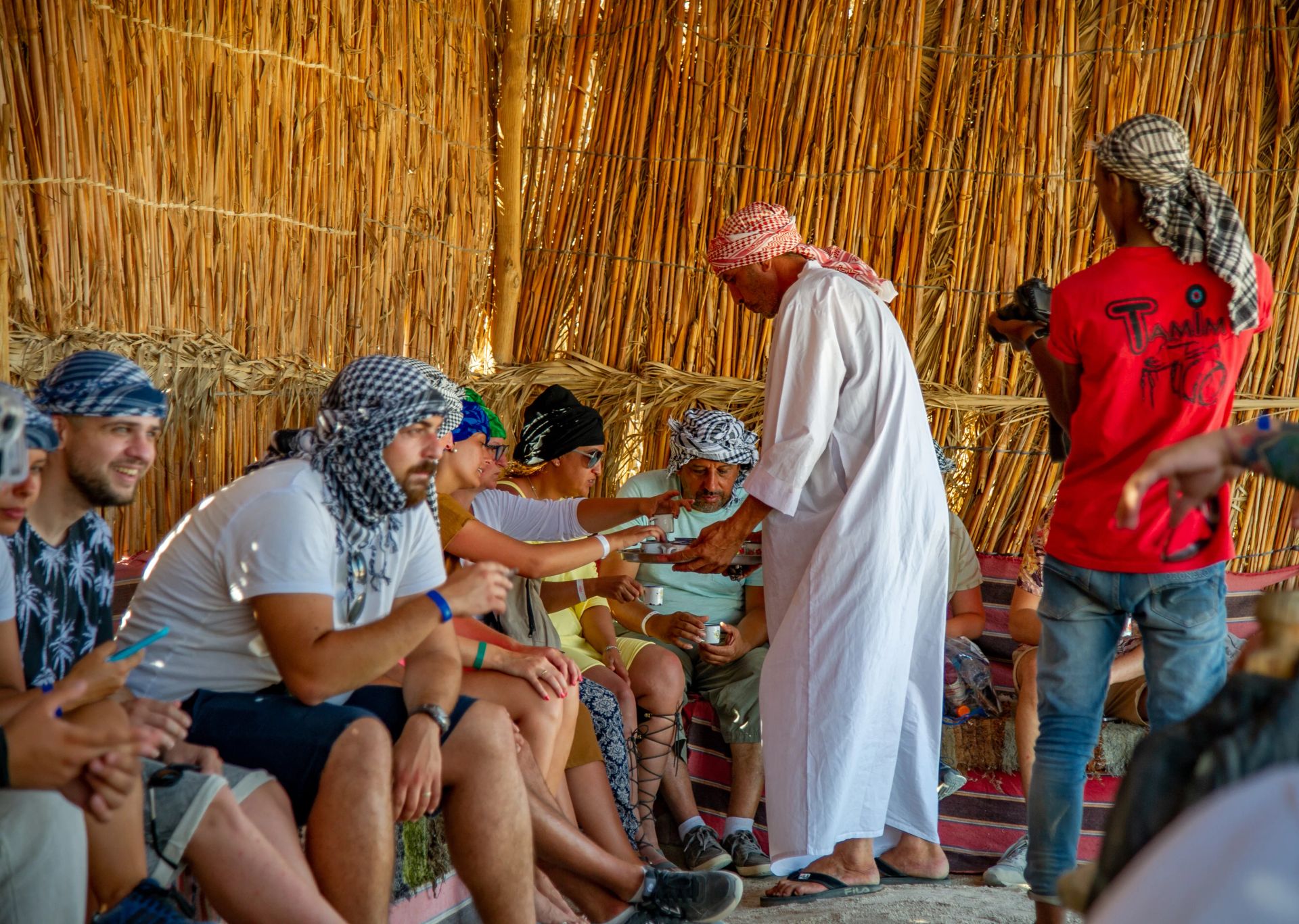 Beduin częstuje uczestników herbatą w namiocie z trzciny w wiosce Beduinów podczas safari z Marsa Alam