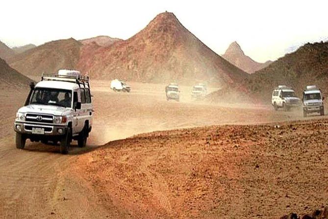 Konwój białych jeepów 4x4 na kamienistej pustyni w górach podczas Jeep Safari z Marsa Alam