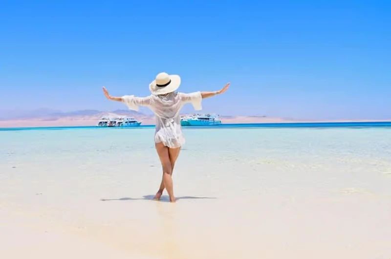 Biała, piaszczysta wyspa (White Island / Biała Wyspa) pośrodku turkusowego morza z zacumowanymi łodziami - Morze Czerwone koło Sharm el Sheikh