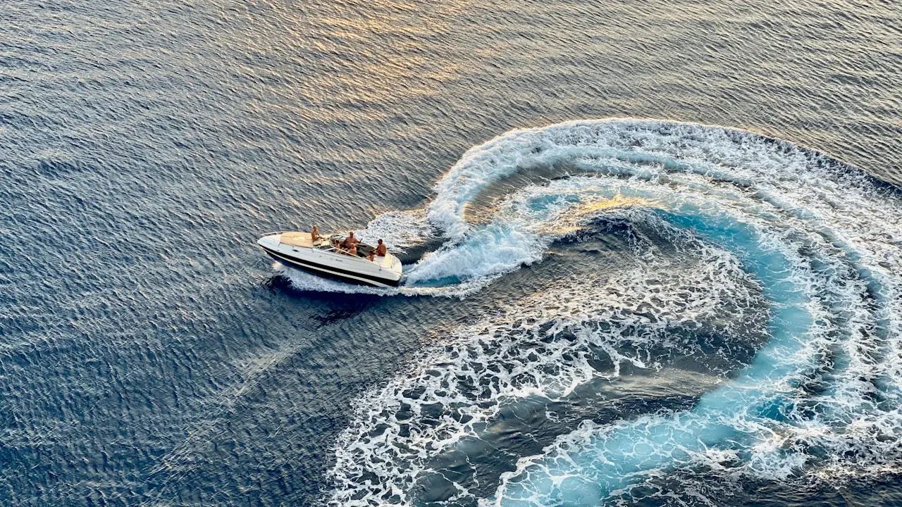 Prywatny speed boat płynie po Morzu Czerwonym w okolicy Hurghady - widok z lotu ptaka na białą łódź i pieniący się kilwater