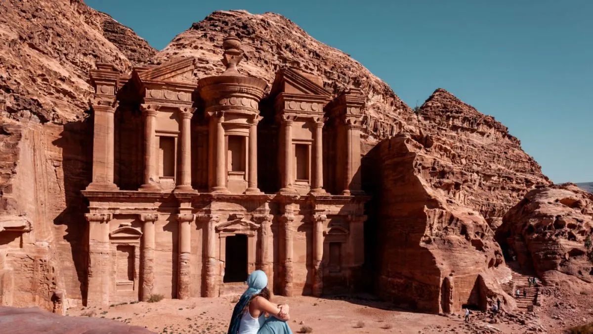 Klasztor (Ad-Deir) w Petrze w Jordanii - monumentalna fasada wykuta w skale z osobą podziwiającą widok