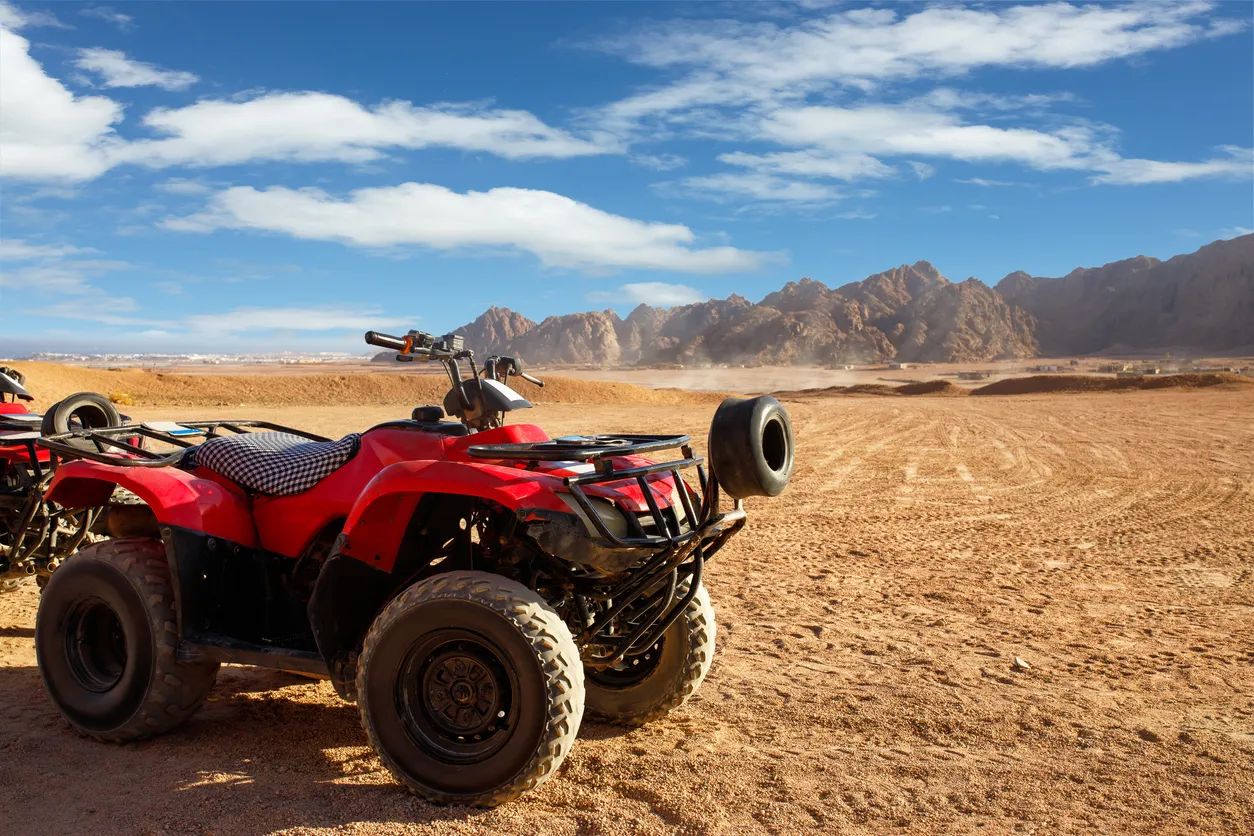 Quad safari 5h na pustyni Synaj - czerwony quad na tle skalistych gór podczas wycieczki z Sharm el Sheikh