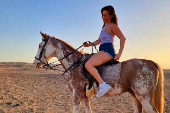 Jeździec na srokatym koniu na pustyni o zachodzie słońca w okolicy Sharm el Sheikh