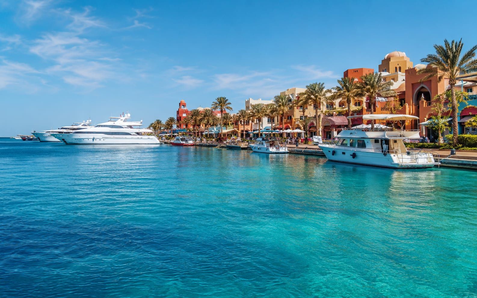 Marina w Hurghadzie z jachtami i kolorowymi budynkami nad turkusowym Morzem Czerwonym