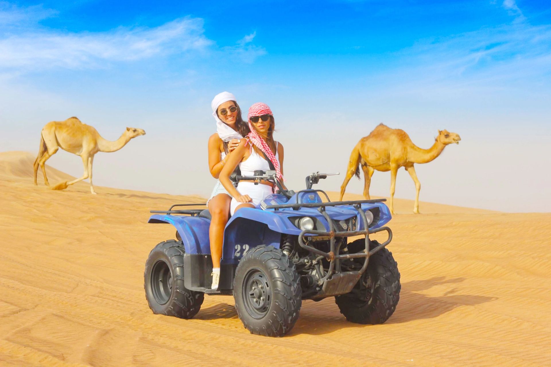 Uczestnicy na quadzie i wielbłądy na pustyni podczas Super Safari z Marsa Alam