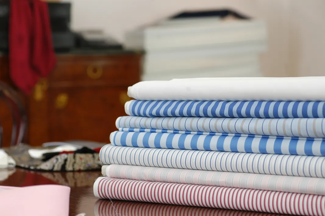 shirt-making fabrics folded in a pile.