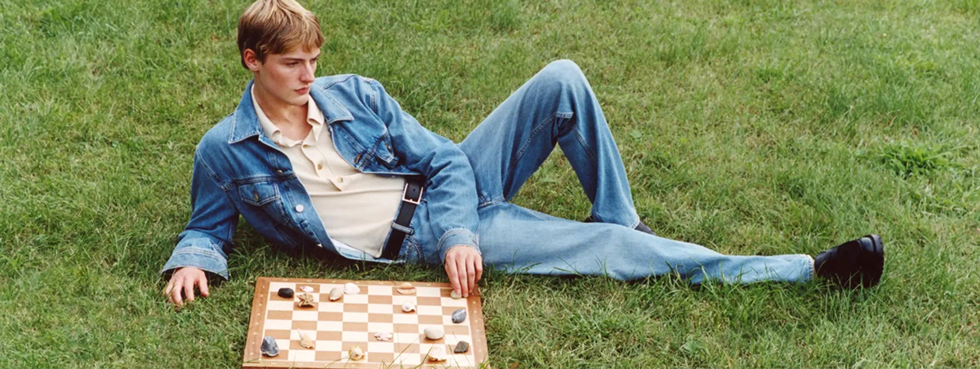 Man wearing Jacob Cohën playing drafts in a field.