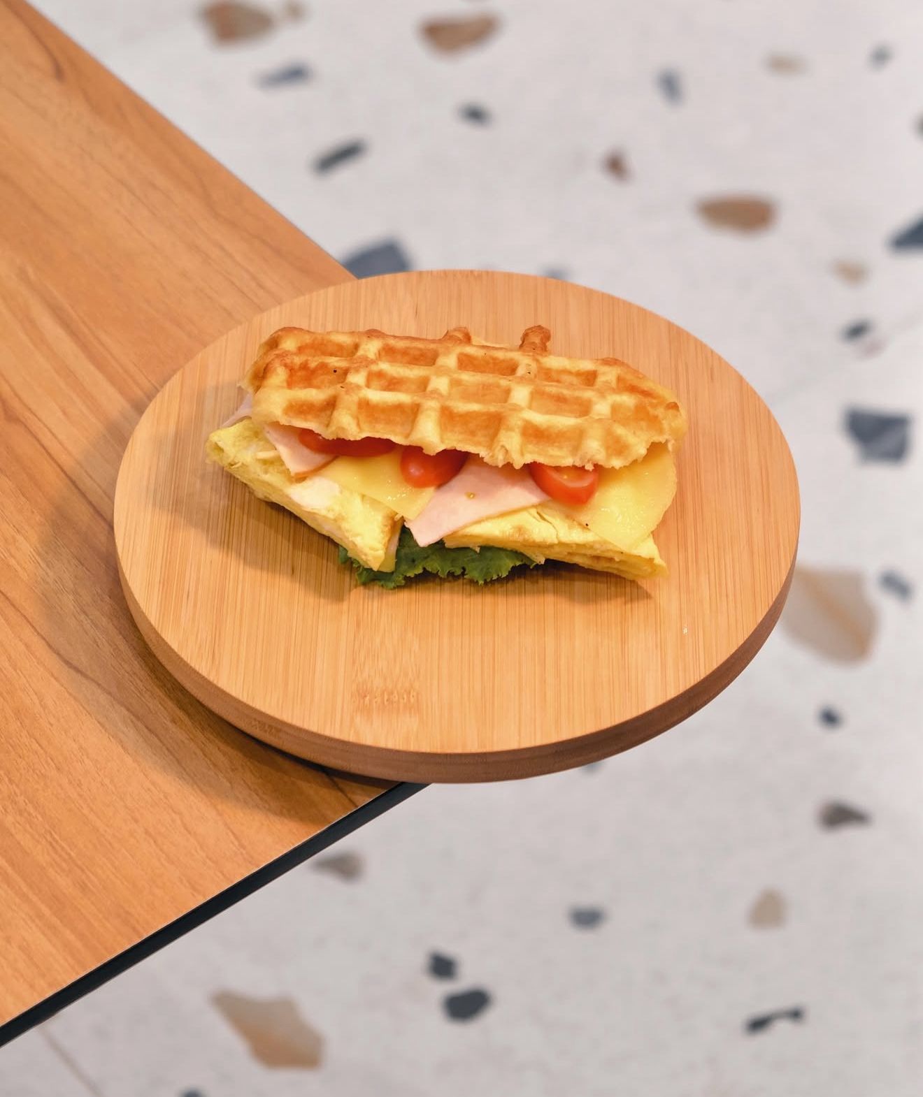 Savory Egg and Turkey Waffle Sandwich on Wooden Board at Asador Coffee El Jadida