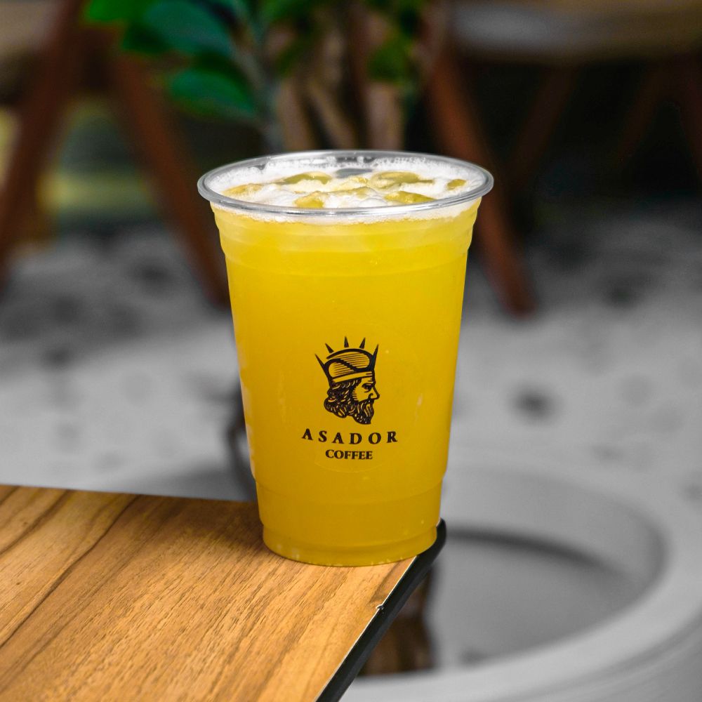 Iced Tropical Lemonade with Passion Fruit Peach and Coconut in Plastic Cup at Asador Coffee El Jadida