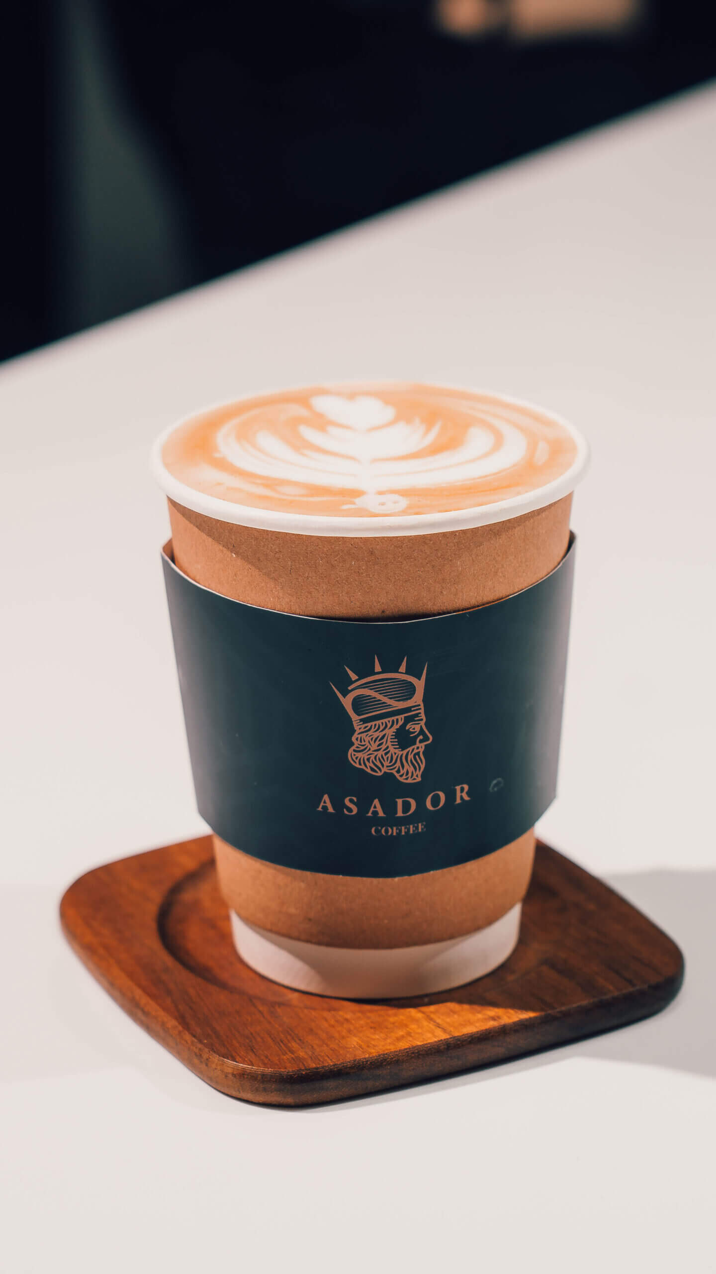 Classic Cortado Coffee in Glass Cup on Wooden Coaster at Asador Coffee El Jadida