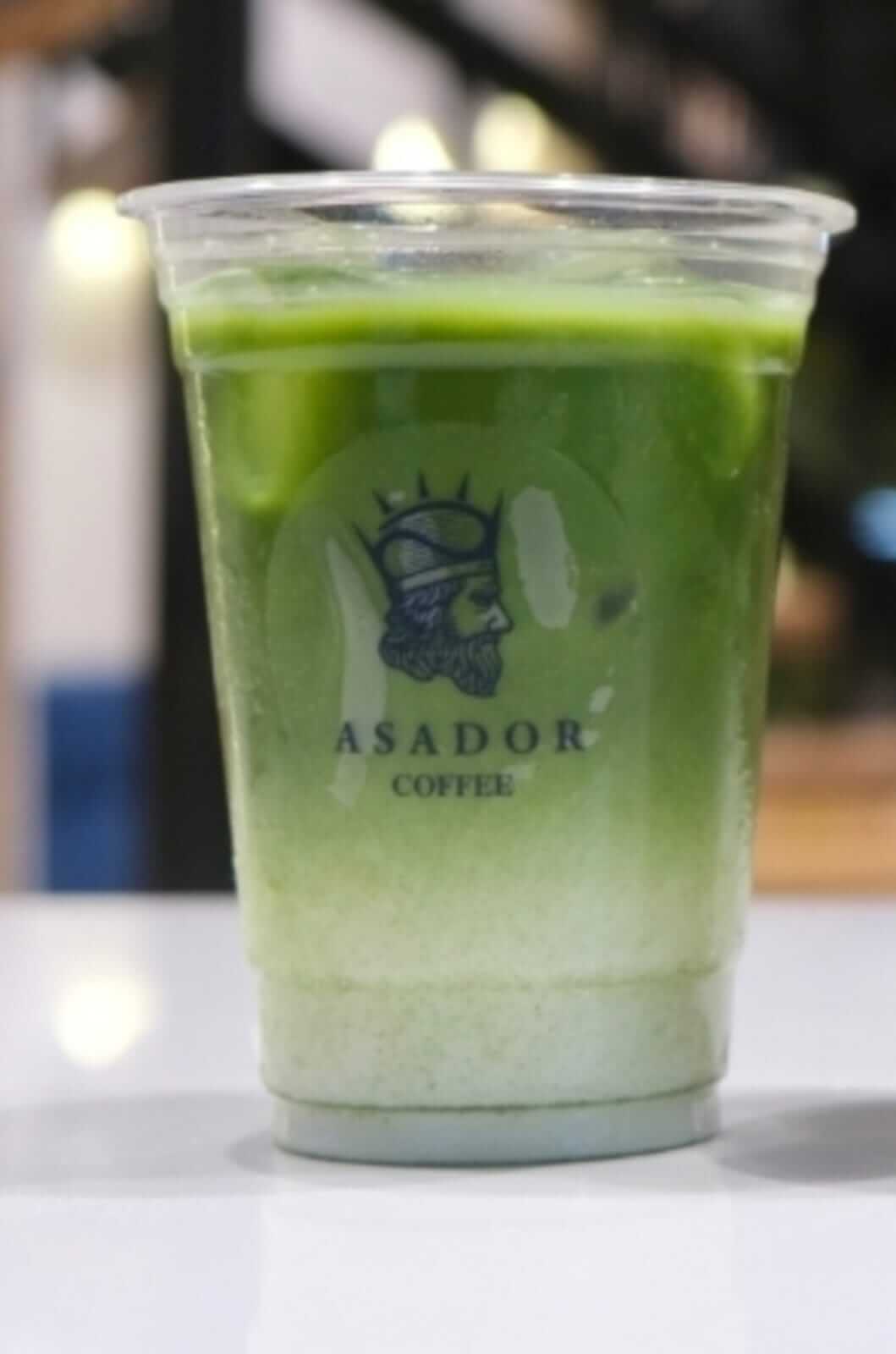 Iced Classic Matcha Green Tea Latte with Milk Layers in Plastic Cup at Asador Coffee El Jadida