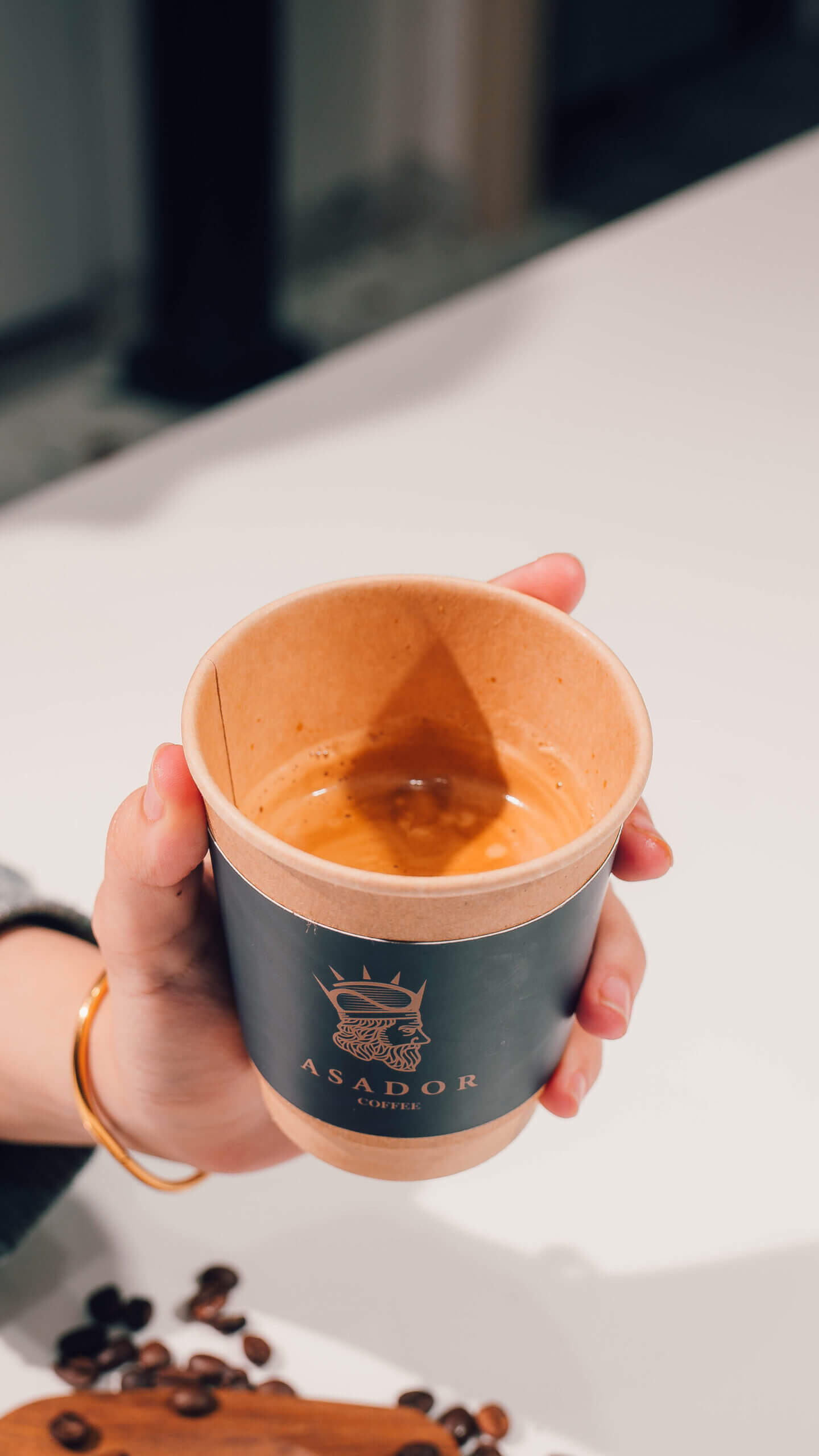 Hand Holding Fresh Espresso Shot in Small Takeaway Cup at Asador Coffee El Jadida