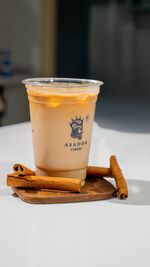 Iced Honey Pumpkin Spice Latte with Cinnamon Sticks in Plastic Cup at Asador Coffee El Jadida