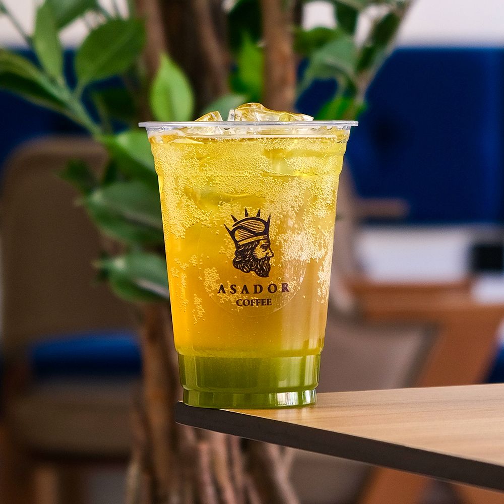 Iced Green Apple Energy Drink with Apple Slices in Plastic Cup at Asador Coffee El Jadida