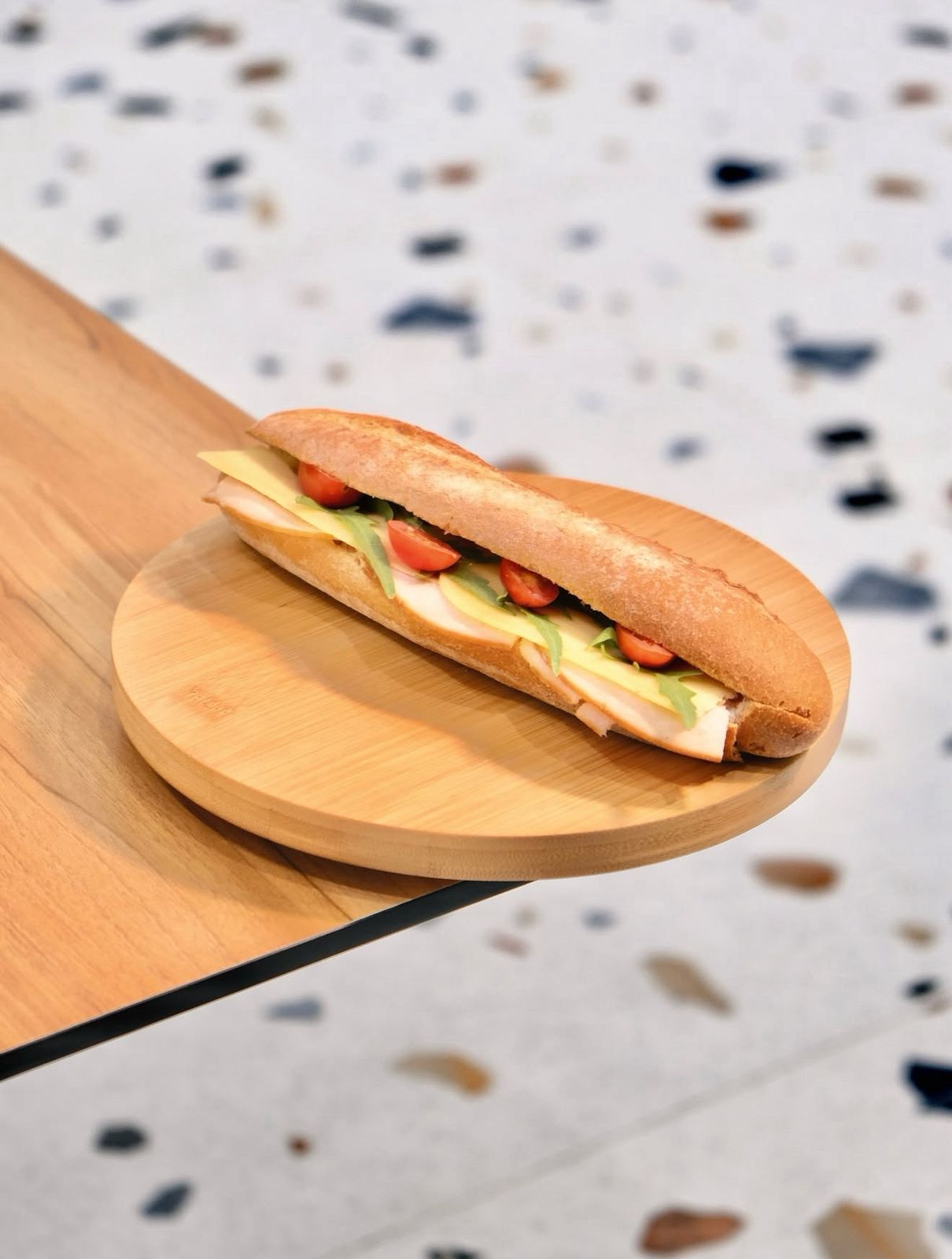 Fresh Smoked Turkey and Cheese Baguette Sandwich on Wooden Board at Asador Coffee El Jadida