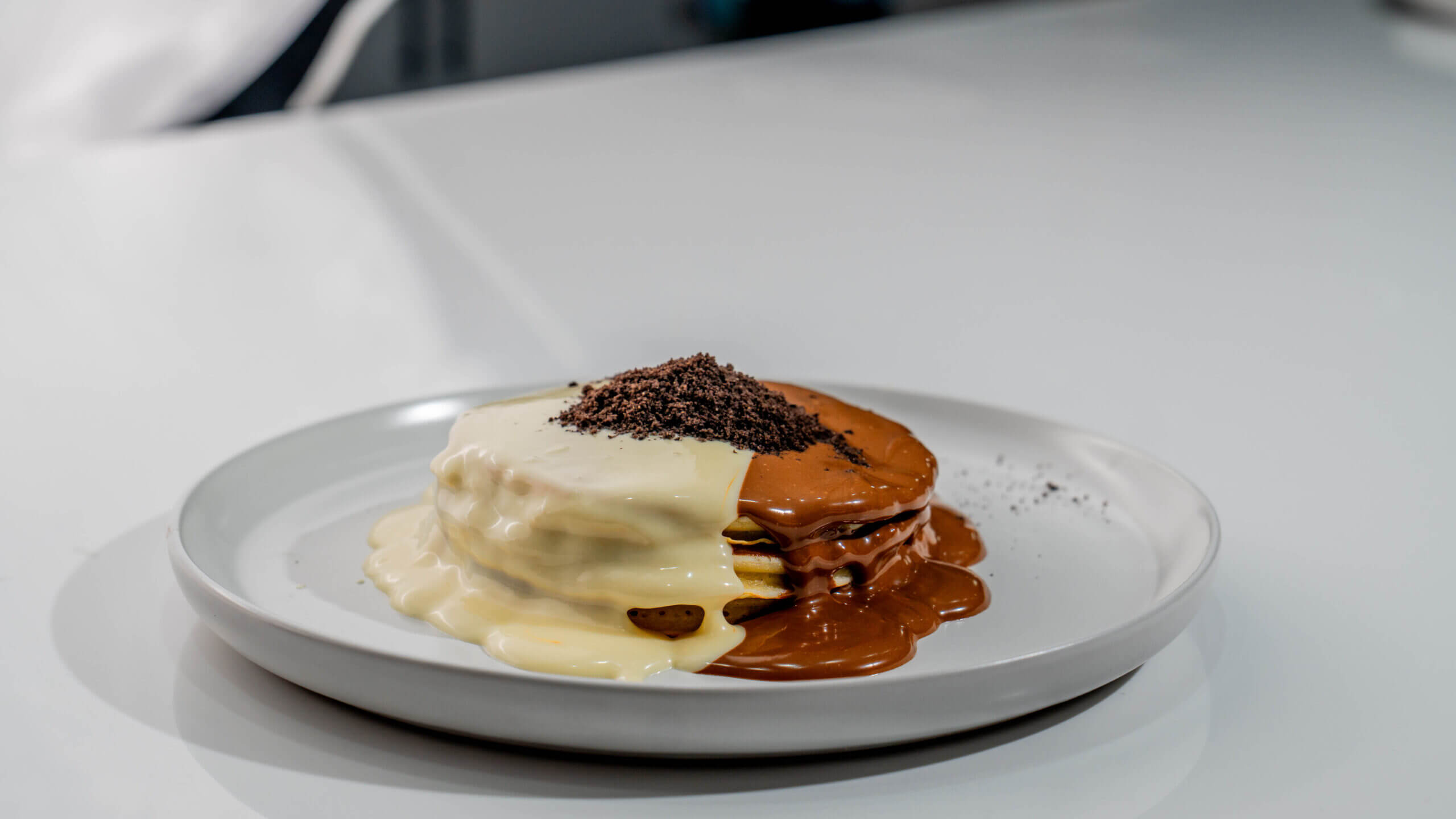 Fluffy Ferrero Pancakes with Half Milk Chocolate and Half White Chocolate Topping at Asador Coffee El Jadida