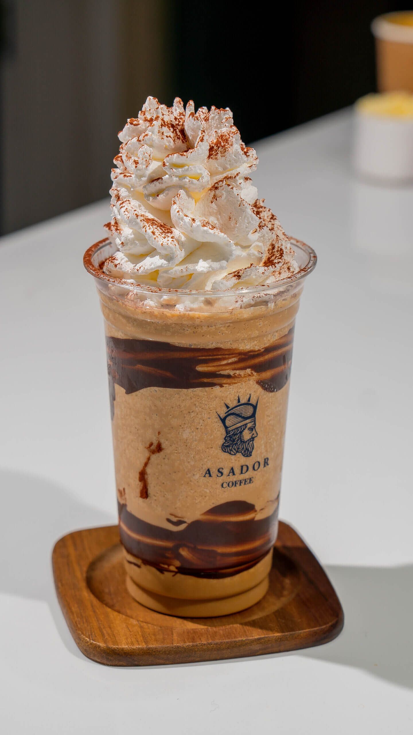 Iced Tiramisu Frappe with Whipped Cream and Cocoa Powder in Plastic Cup at Asador Coffee El Jadida