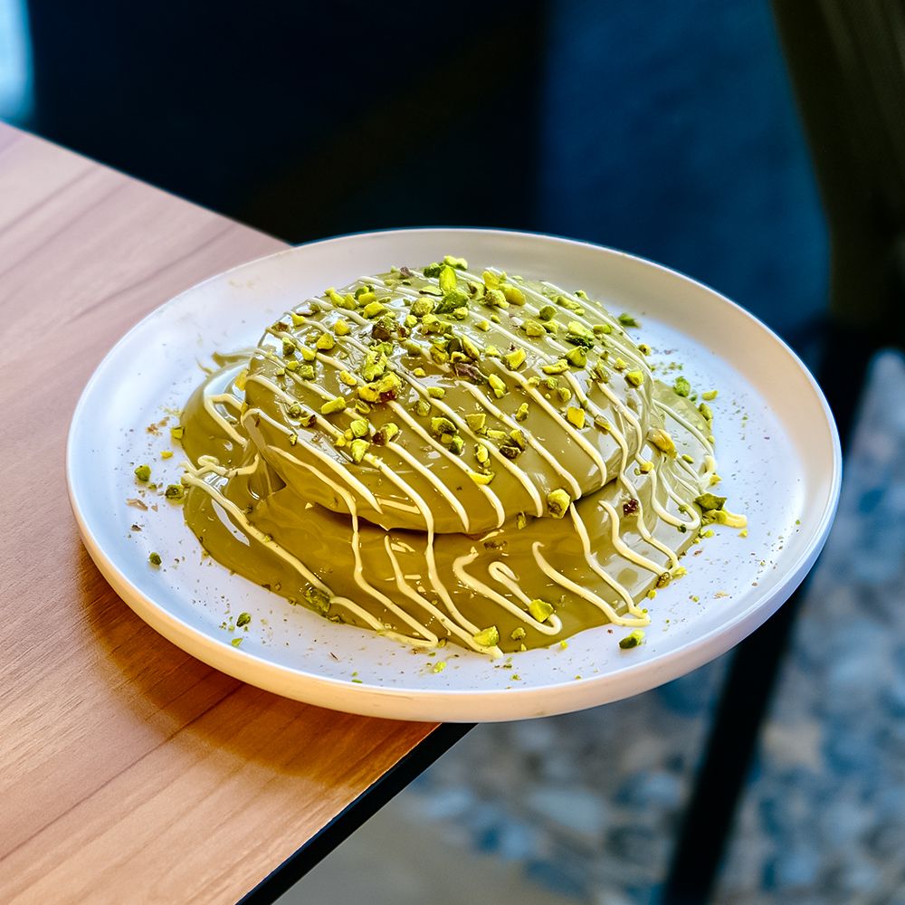 Stack of Fluffy Pistachio Pancakes with Cream Cheese Filling and Green Pistachio Sauce at Asador Coffee El Jadida