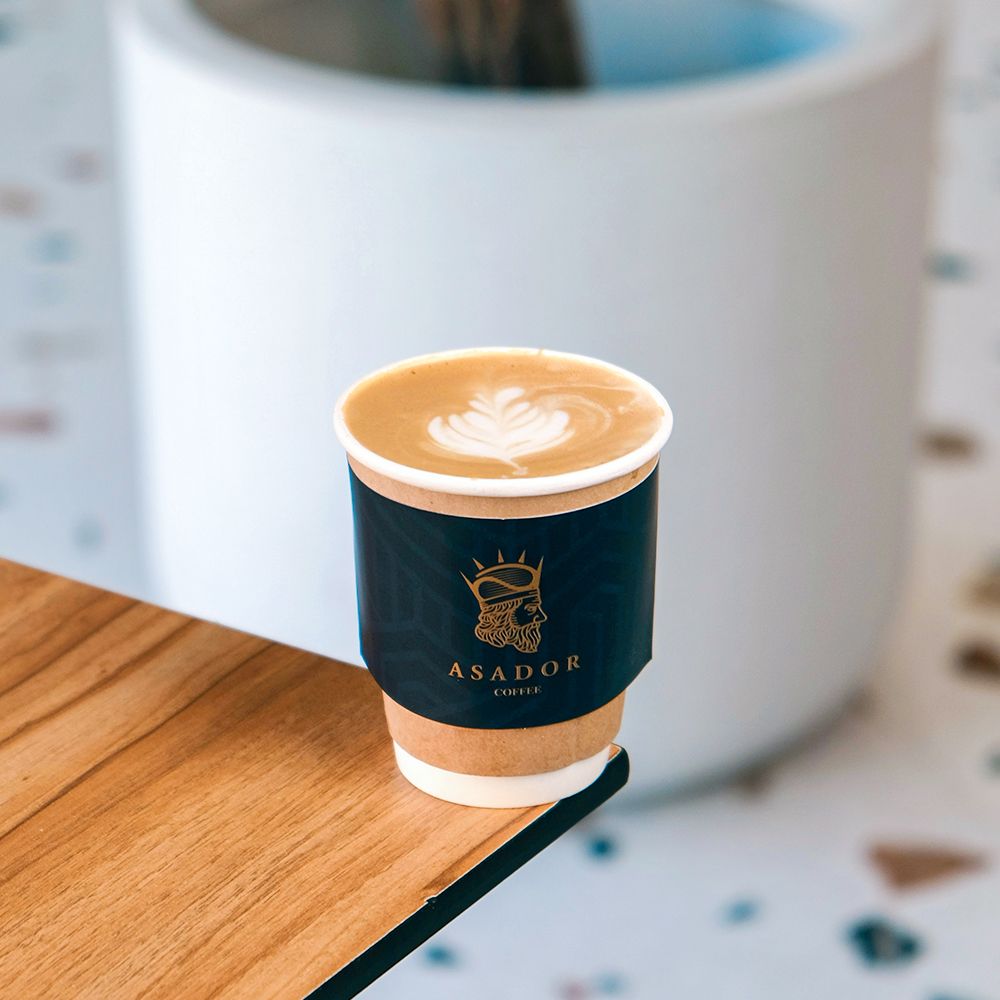 Hot Cafe Latte in Branded Cup with Heart Latte Art on Wooden Coaster at Asador Coffee El Jadida