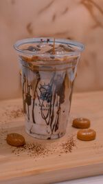 Iced Salted Caramel Latte with Caramel Drizzle in Plastic Cup at Asador Coffee El Jadida