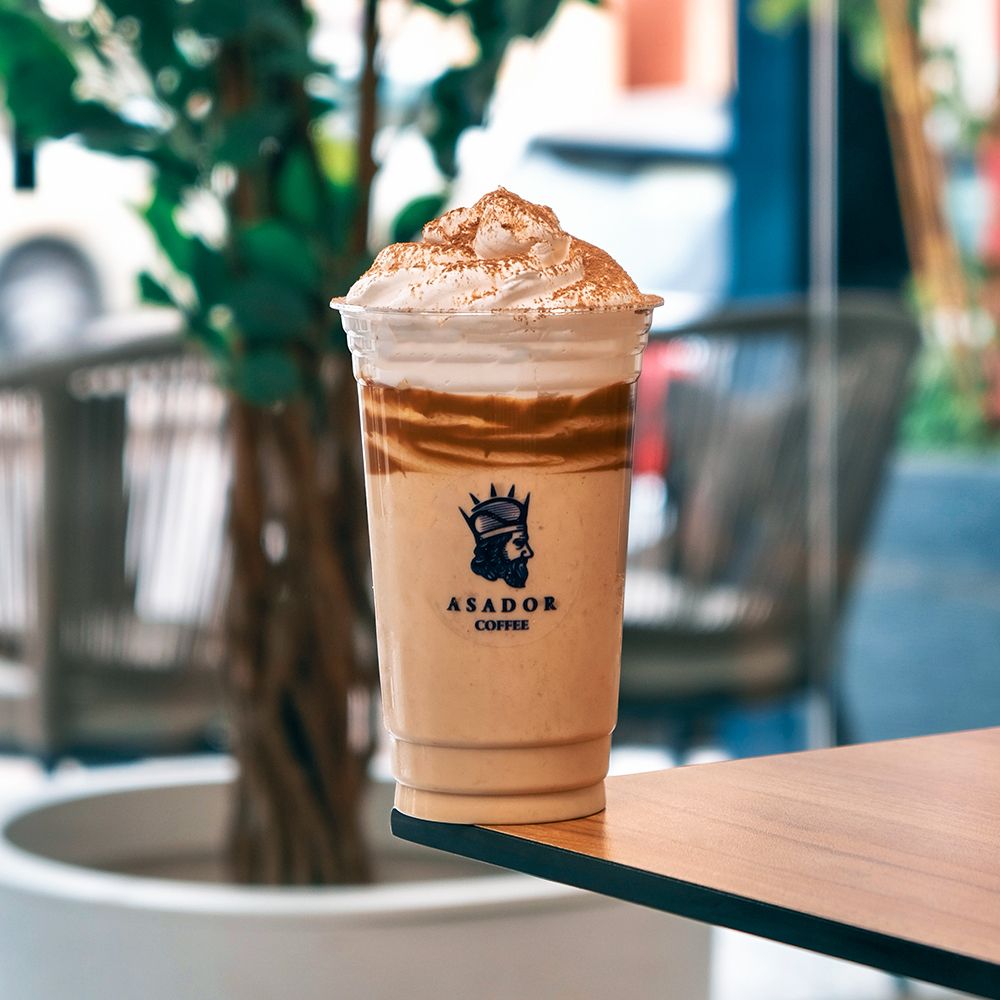 Thick Cappuccino Milkshake with Whipped Cream and Chocolate Drizzle in Plastic Cup at Asador Coffee El Jadida