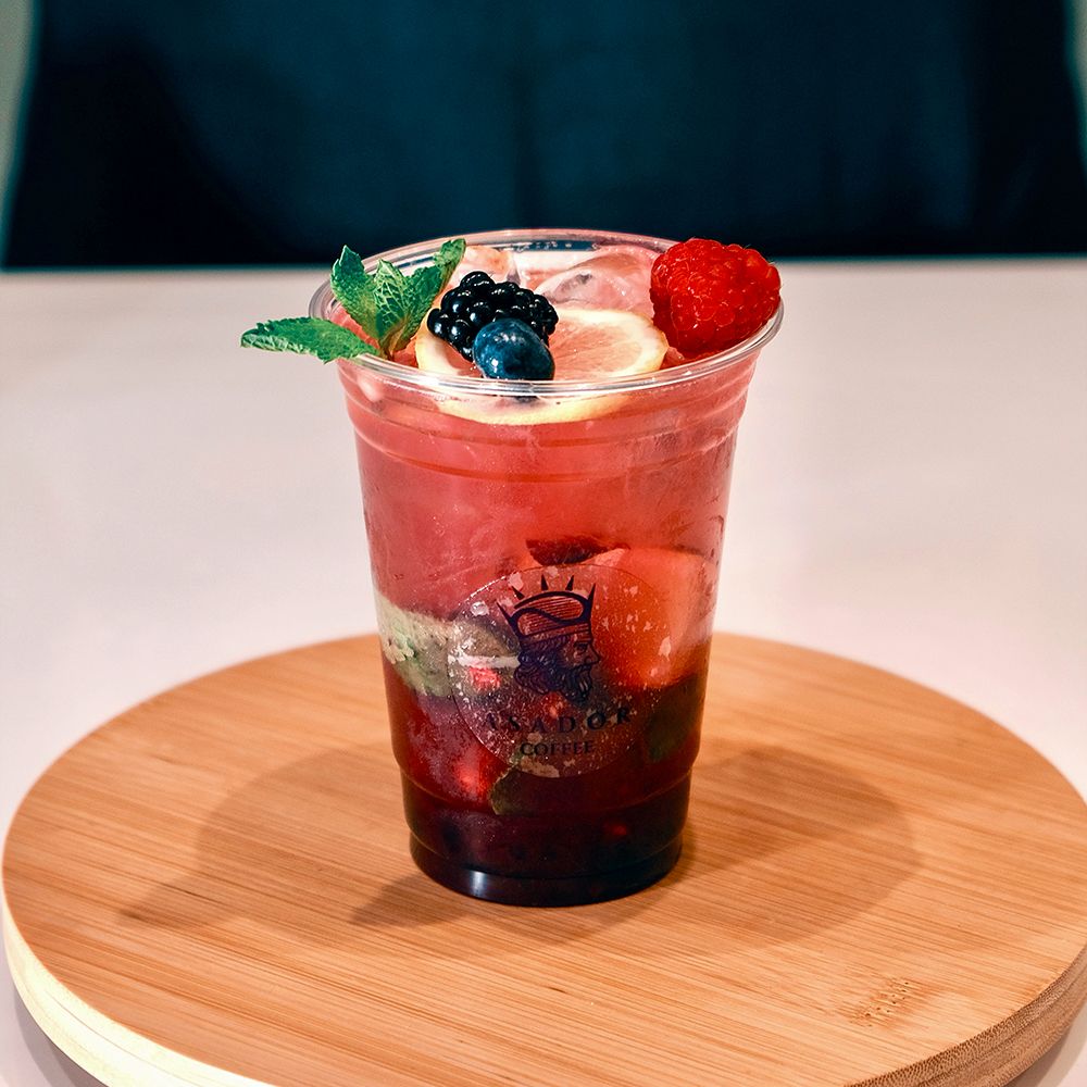 Iced Mixed Berry Mojito with Blueberries Raspberries and Mint in Plastic Cup at Asador Coffee El Jadida