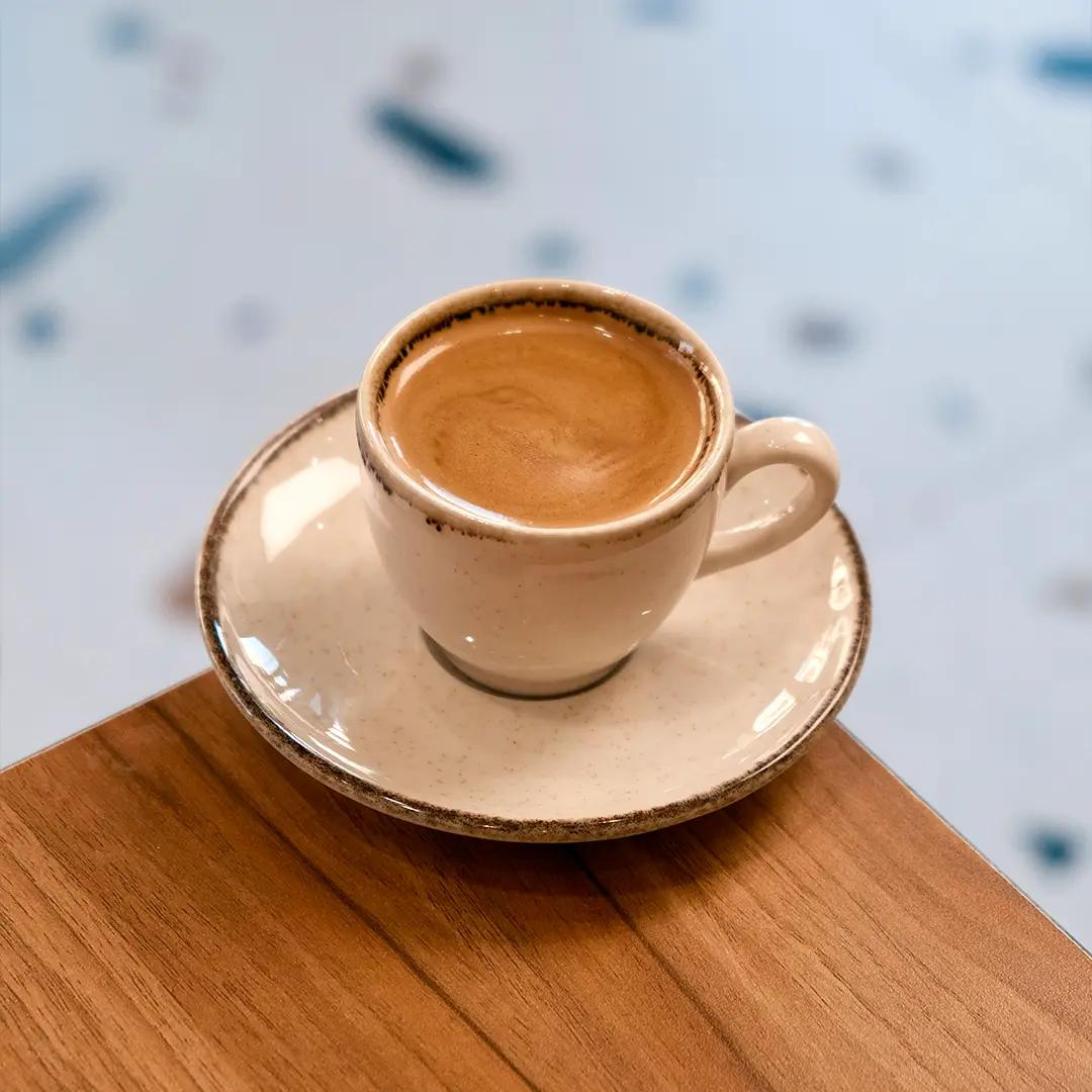 Hand Holding Fresh Espresso Shot in Small Takeaway Cup at Asador Coffee El Jadida