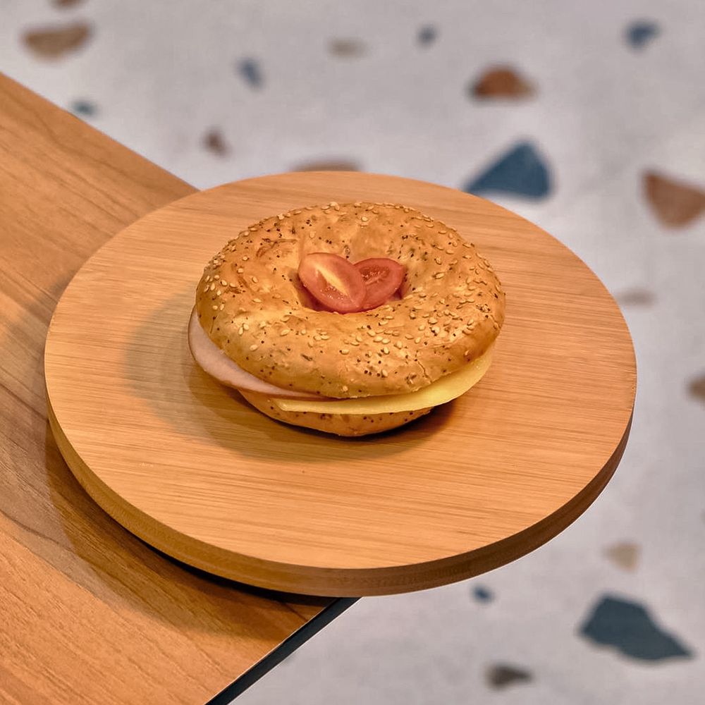 Toasted Turkey and Cheese Bagel Sandwich on Wooden Plate at Asador Coffee El Jadida