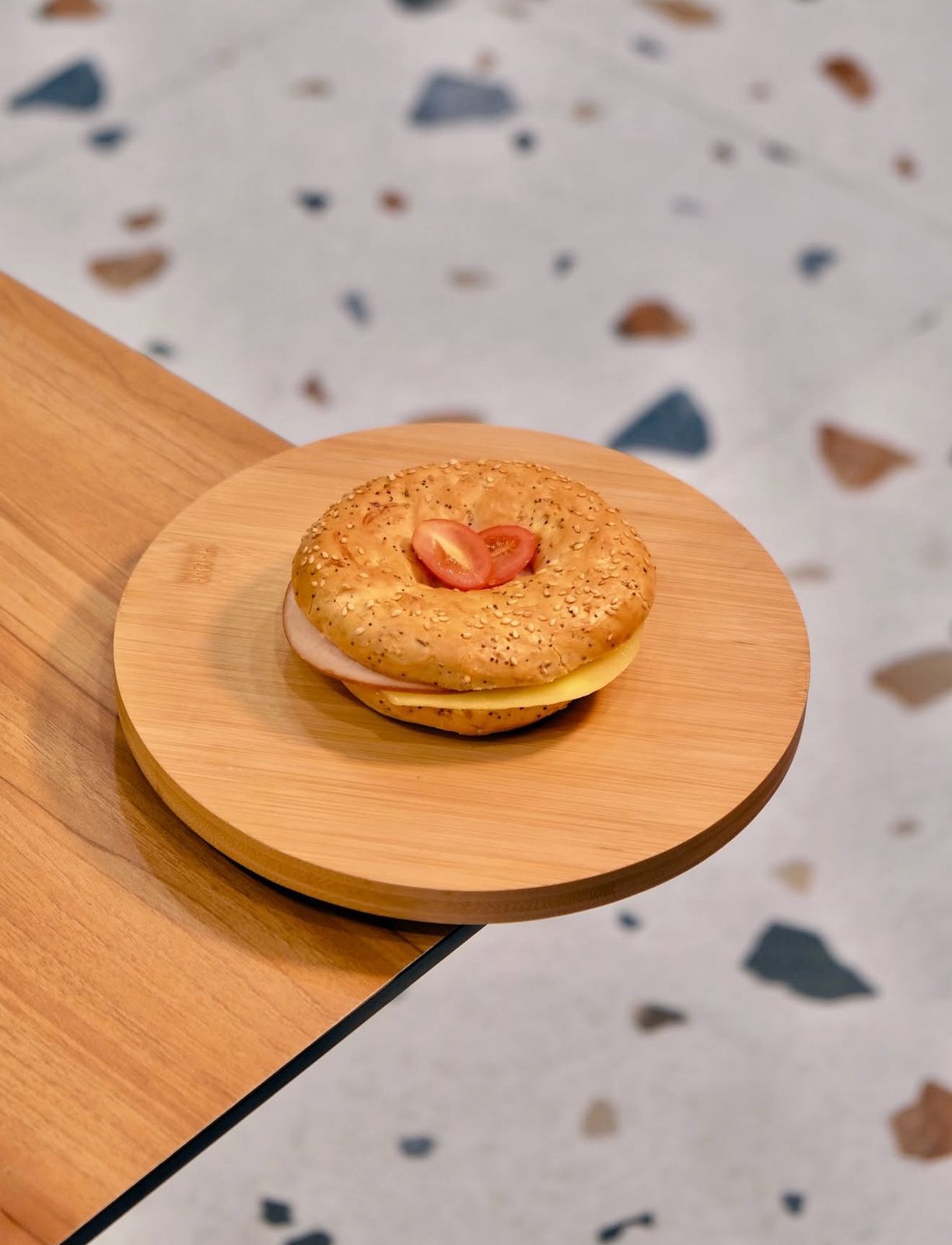 Toasted Turkey and Cheese Bagel Sandwich on Wooden Plate at Asador Coffee El Jadida