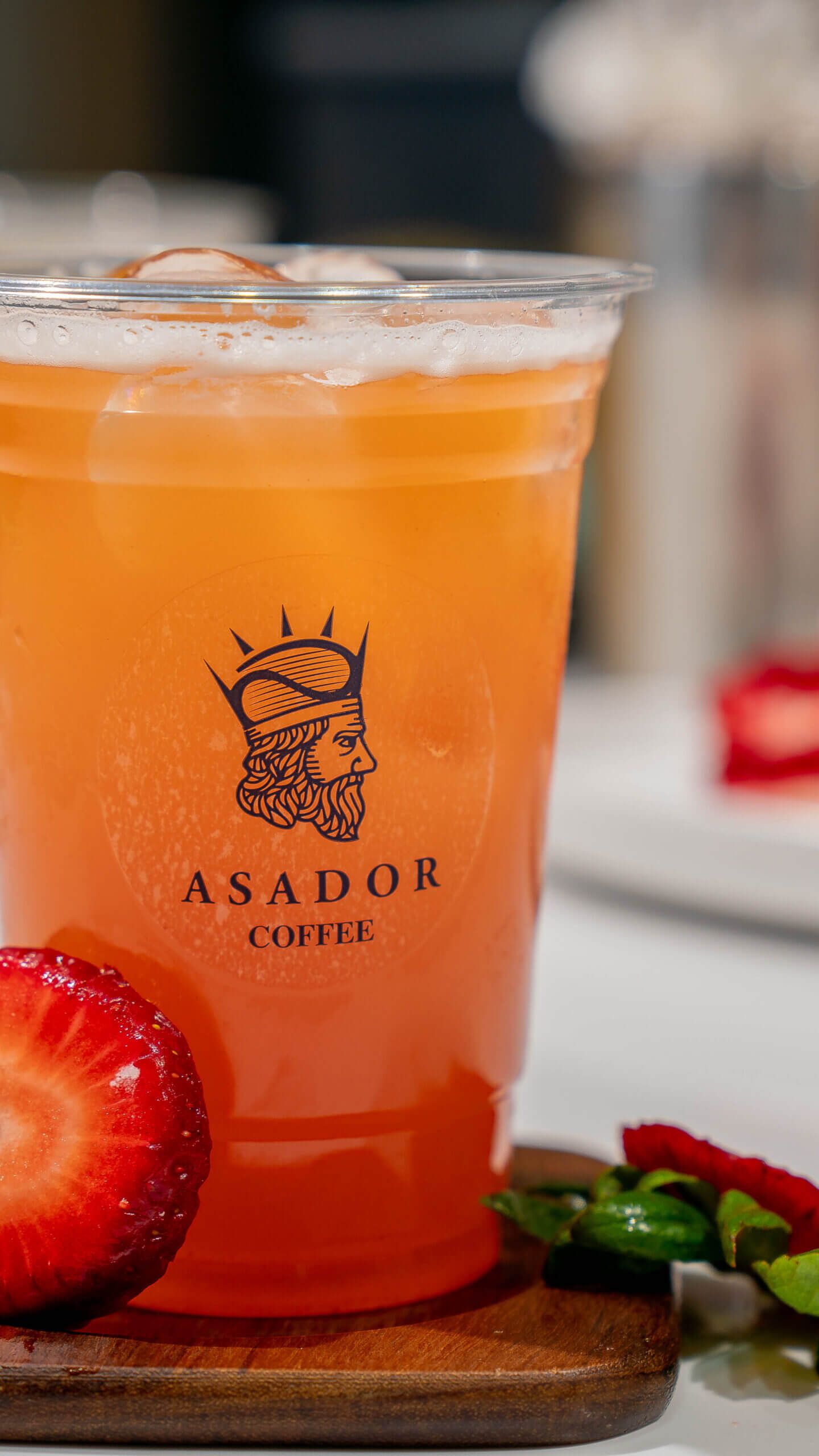 Iced Passion Fruit and Strawberry Lemonade with Fresh Fruit Garnish in Plastic Cup at Asador Coffee El Jadida