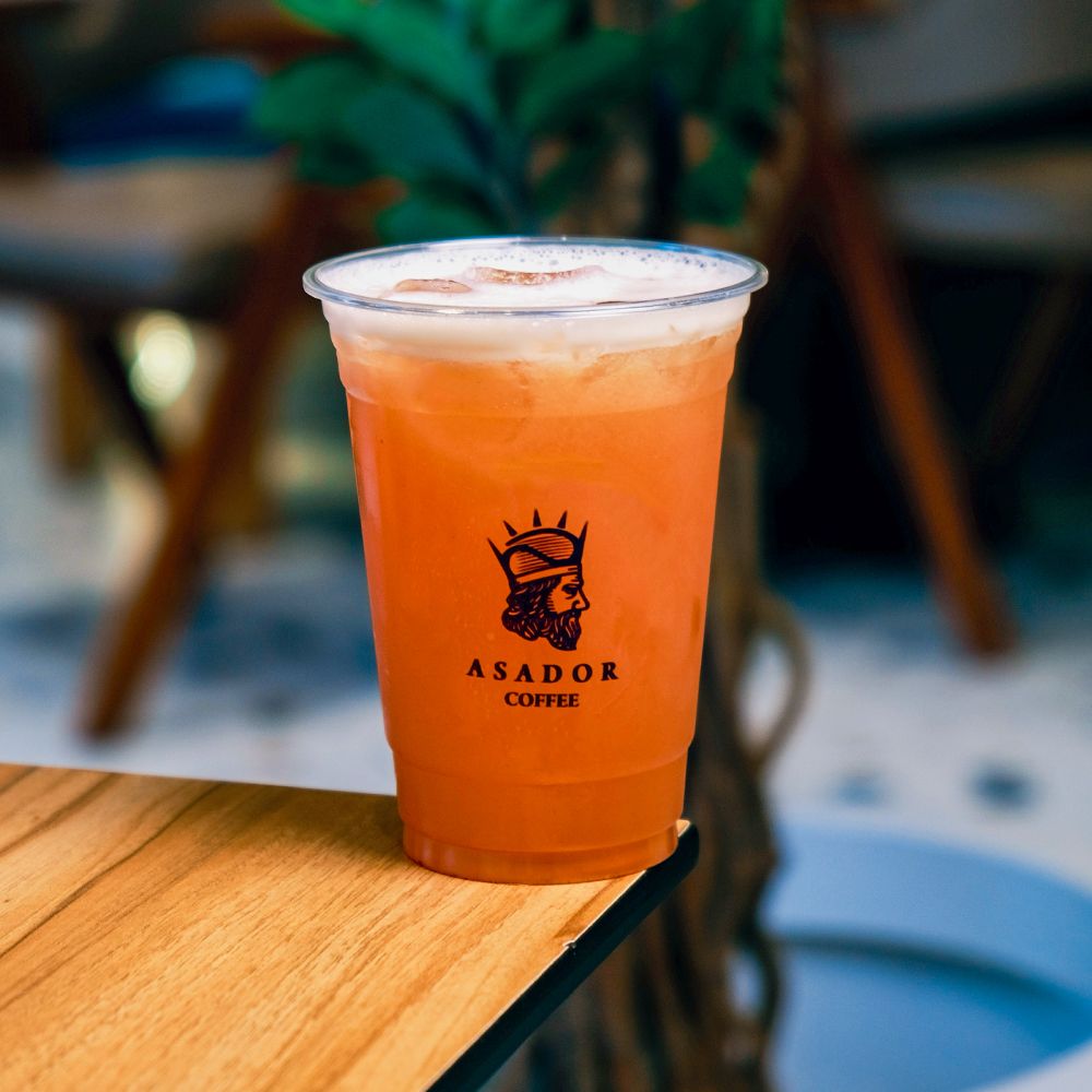 Iced Passion Fruit and Strawberry Lemonade with Fresh Fruit Garnish in Plastic Cup at Asador Coffee El Jadida