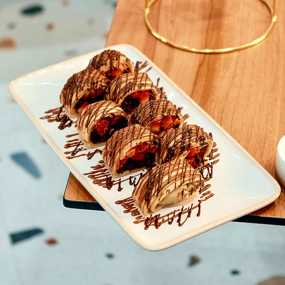 Strawberry Sushi Crepe Rolls Filled with Chocolate Muffin and Fresh Fruit Drizzled in Chocolate at Asador Coffee El Jadida