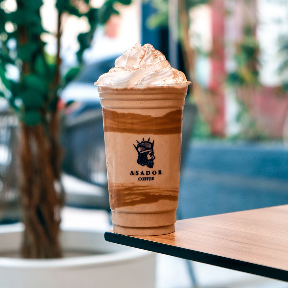 Iced Tiramisu Frappe with Whipped Cream and Cocoa Powder in Plastic Cup at Asador Coffee El Jadida
