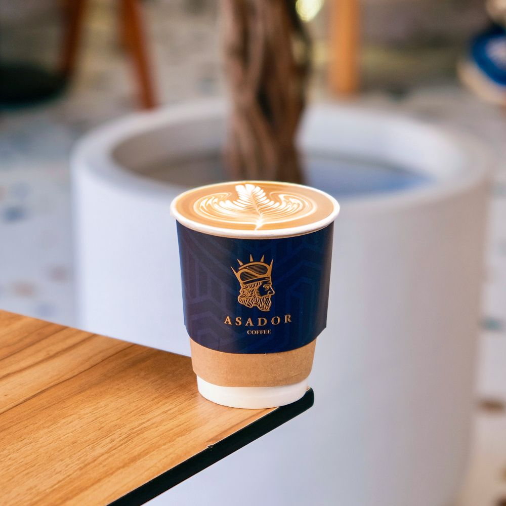 Classic Cortado Coffee in Glass Cup on Wooden Coaster at Asador Coffee El Jadida