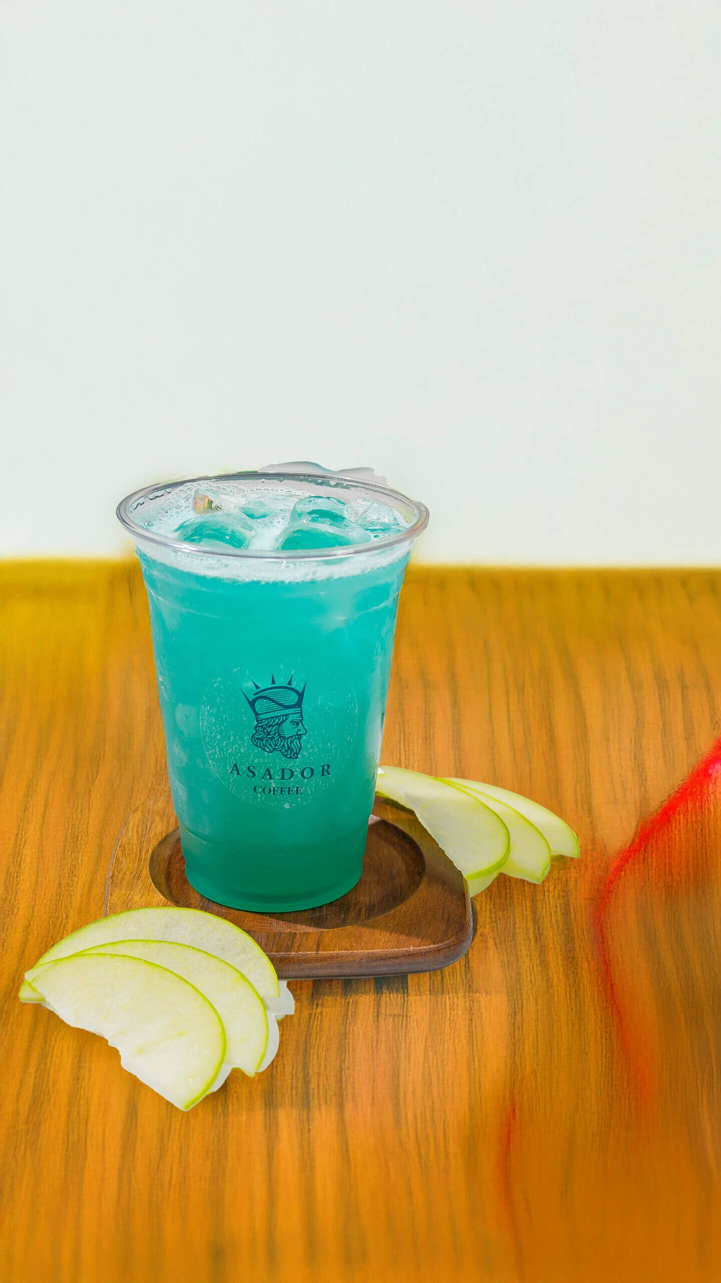 Iced Blue Ocean Lemonade with Green Apple Slices in Plastic Cup at Asador Coffee El Jadida