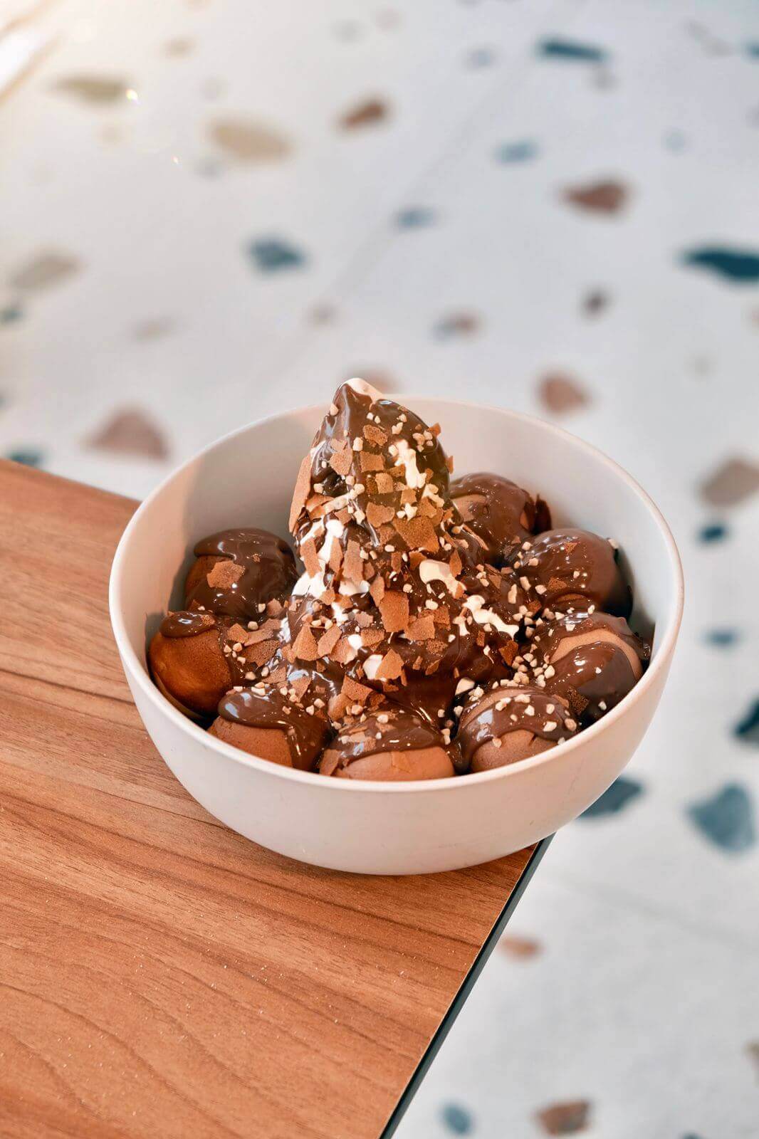 Signature Ferrero Rocher Cake Bombs with Chocolate Glaze, Ice Cream, and Toasted Almonds at Asador Coffee El Jadida