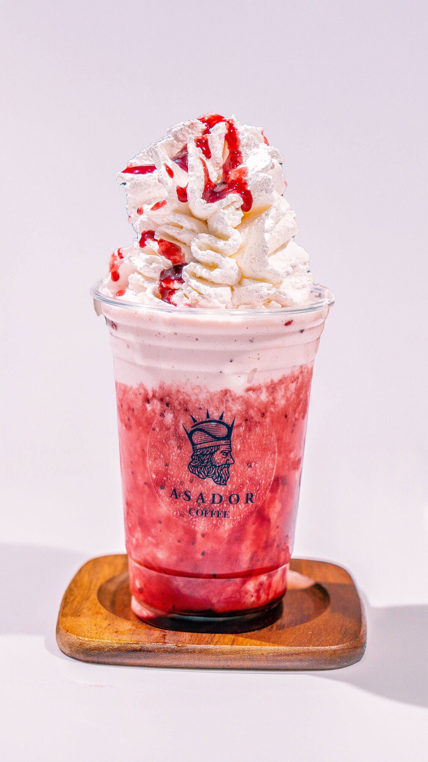 Iced Red Velvet Milkshake with Whipped Cream and Red Syrup Drizzle in Plastic Cup at Asador Coffee El Jadida