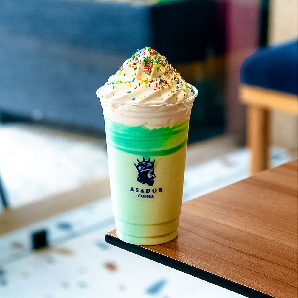 Blue Bubble Gum Milkshake with Whipped Cream and Sprinkles in Plastic Cup at Asador Coffee El Jadida