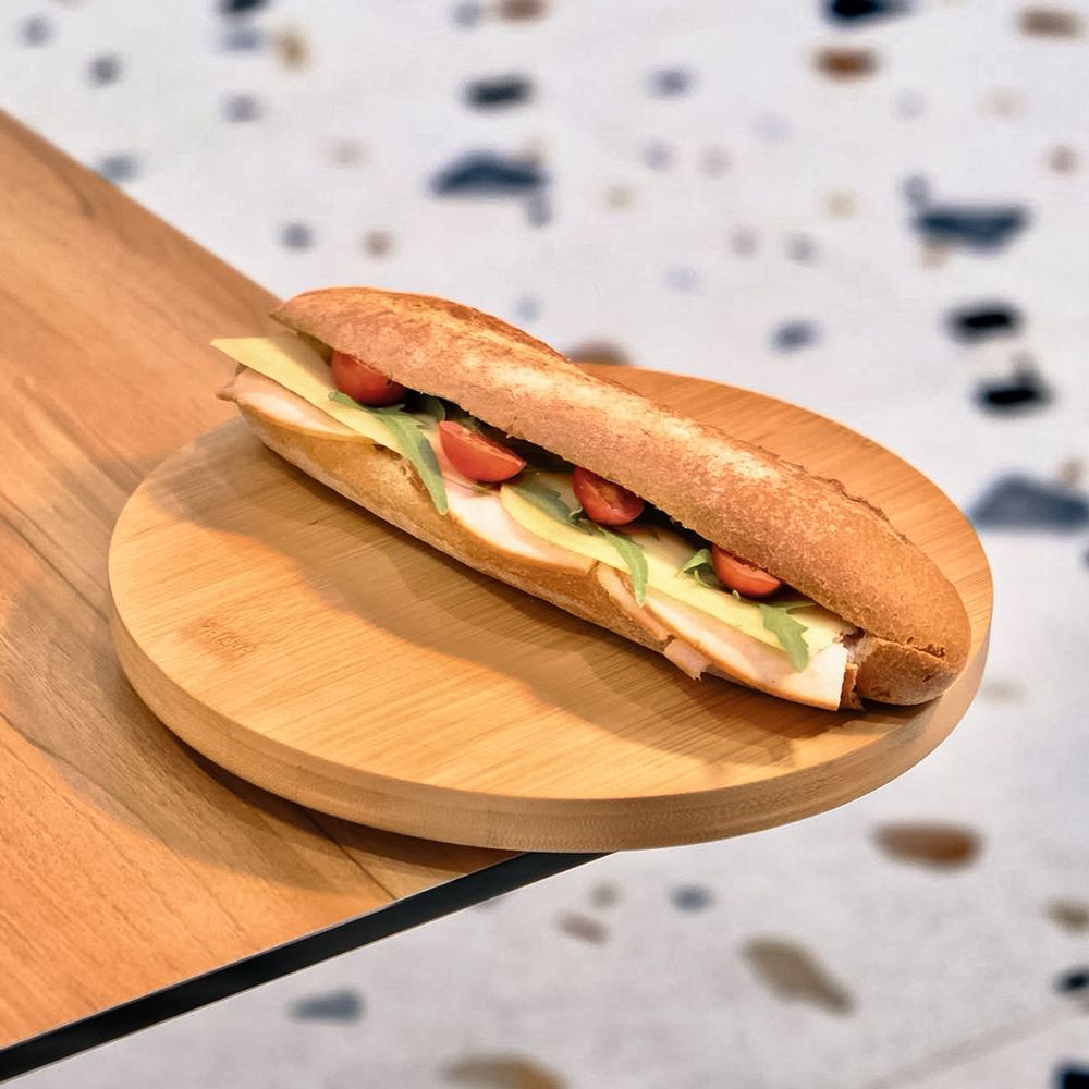 Fresh Smoked Turkey and Cheese Baguette Sandwich on Wooden Board at Asador Coffee El Jadida