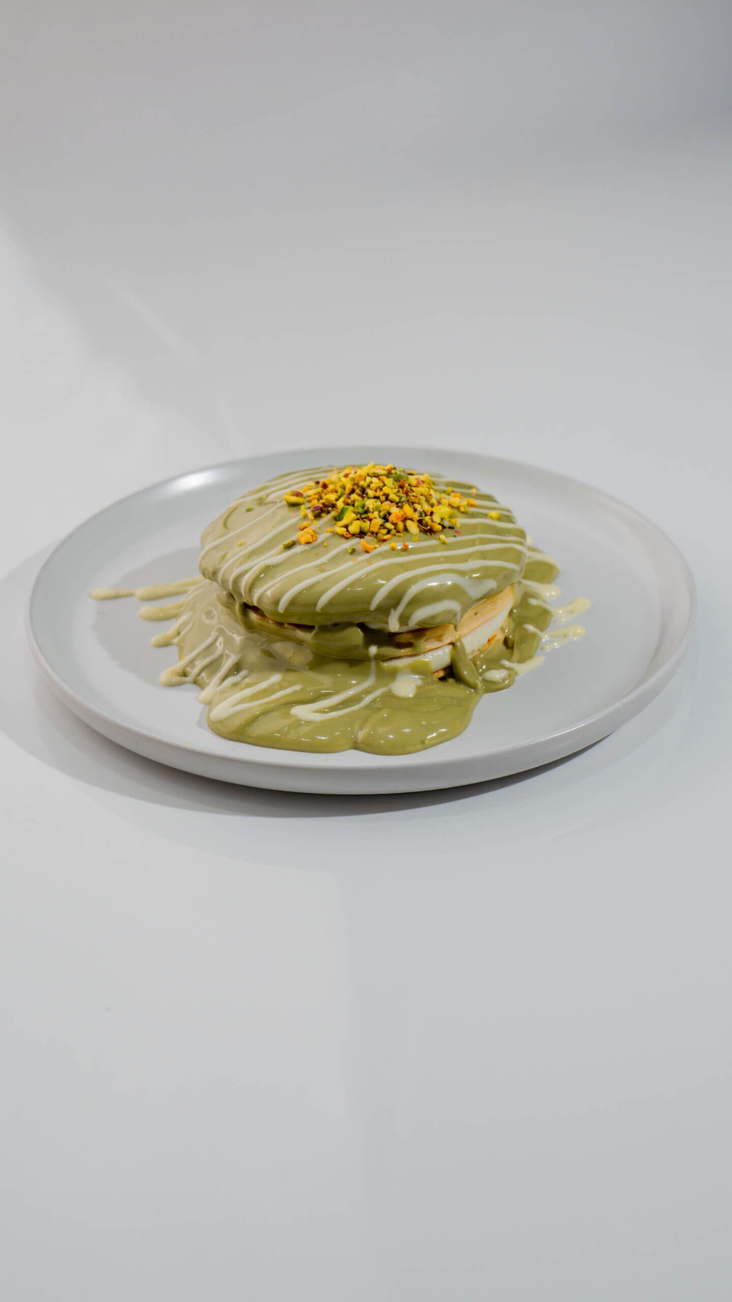 Stack of Fluffy Pistachio Pancakes with Cream Cheese Filling and Green Pistachio Sauce at Asador Coffee El Jadida