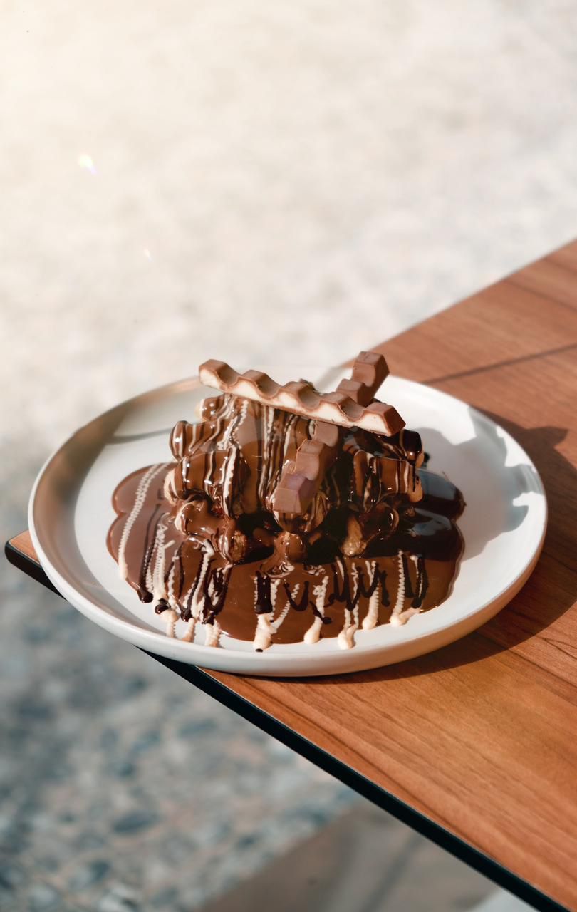 Freshly Baked Kinder Waffle with Melted Milk Chocolate and Kinder Pieces at Asador Coffee El Jadida