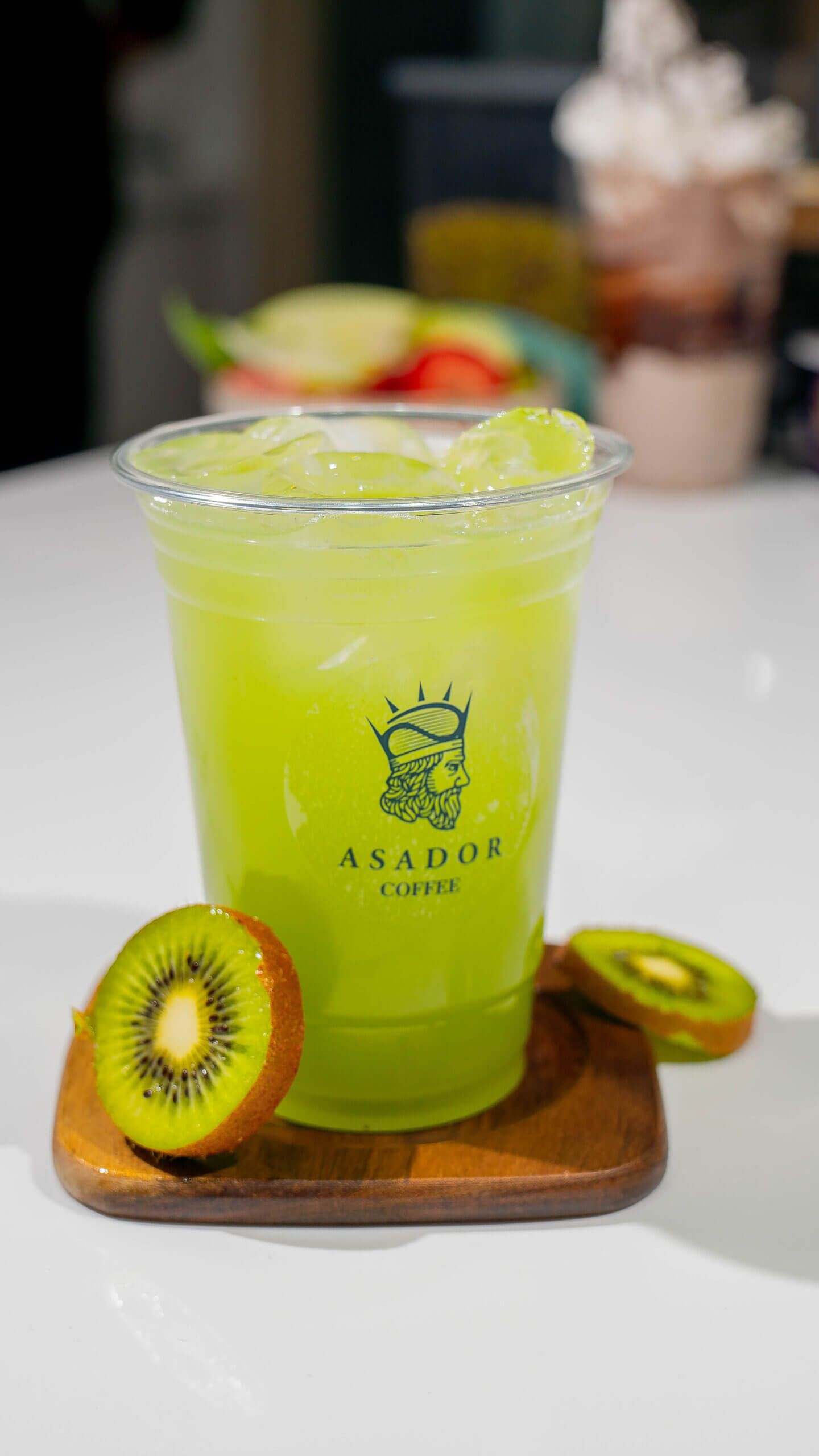 Iced Kiwi Lime Lemonade with Fresh Kiwi Slices in Plastic Cup at Asador Coffee El Jadida