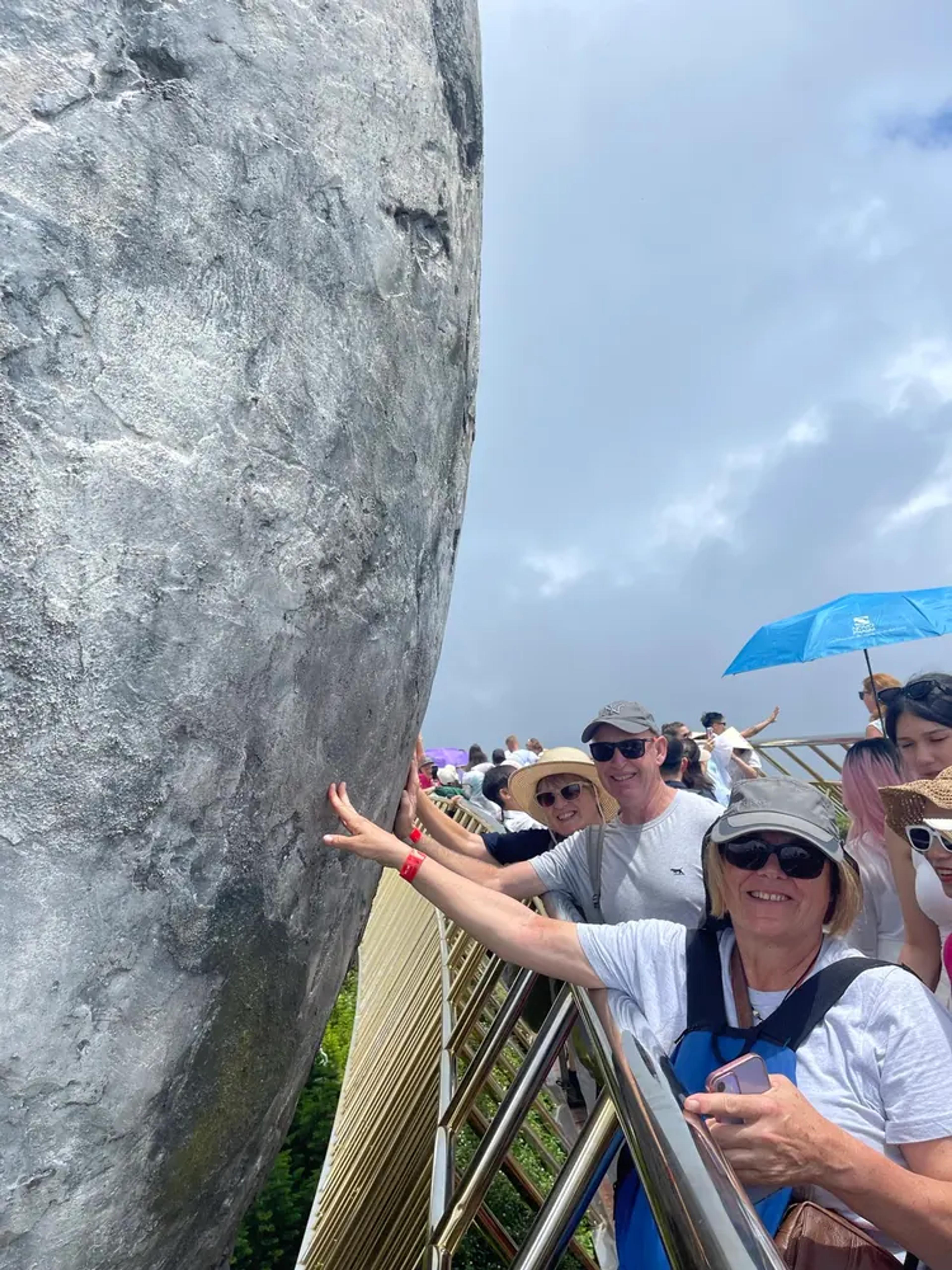 Guests on the Golden Bridge beside one of the giant stone hands at Ba Na Hills