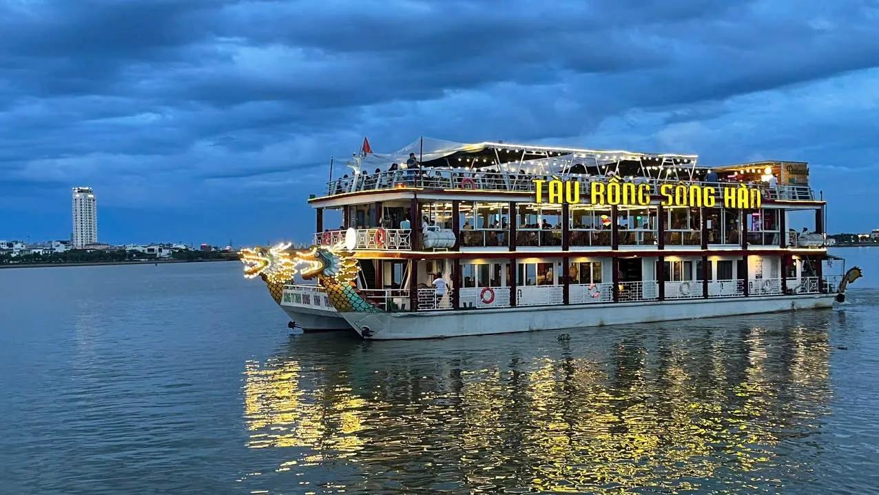 The dragon-prowed Han River cruise boat lit up at dusk in Da Nang