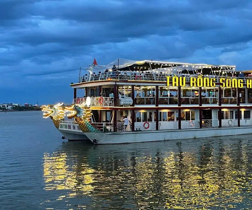 The dragon-prowed Han River cruise boat lit up at dusk in Da Nang