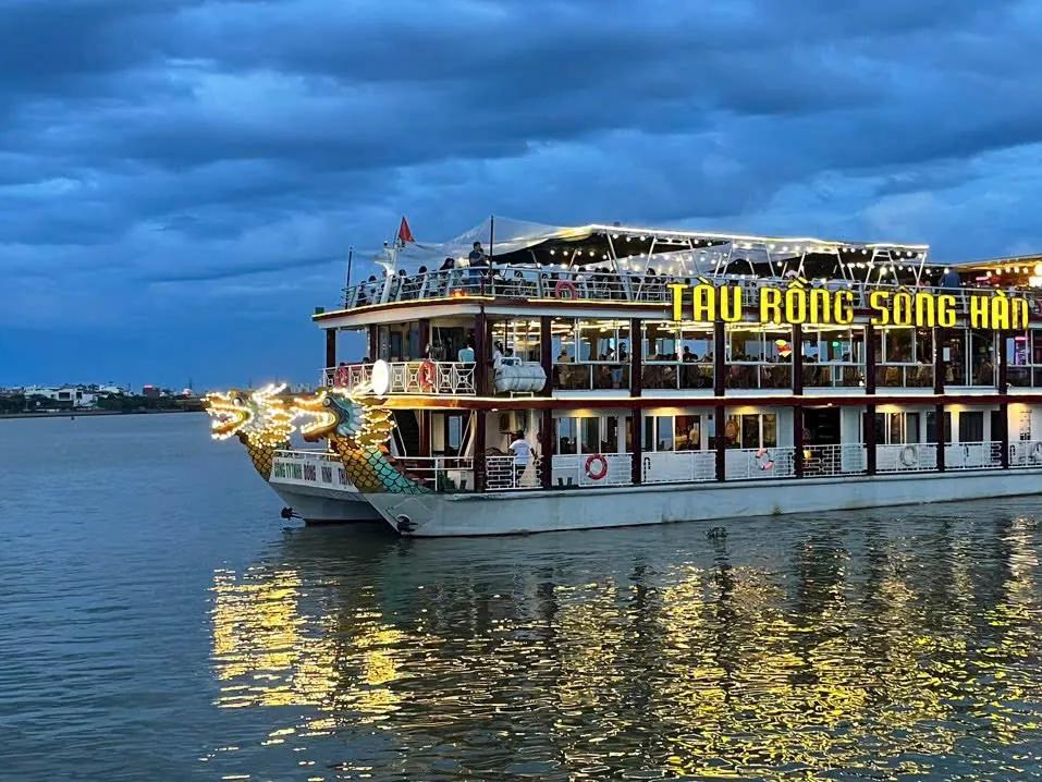 The dragon-prowed Han River cruise boat lit up at dusk in Da Nang